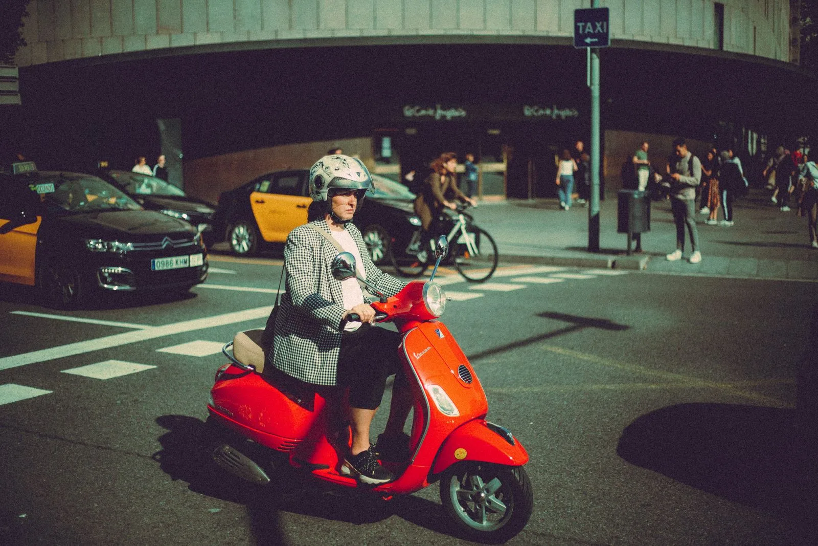 Casco jet in città: motociclista con casco jet su uno scooter rosso