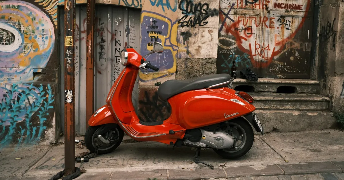 Bloccadisco per scooter: Vespa arancione parcheggiata in un vicolo