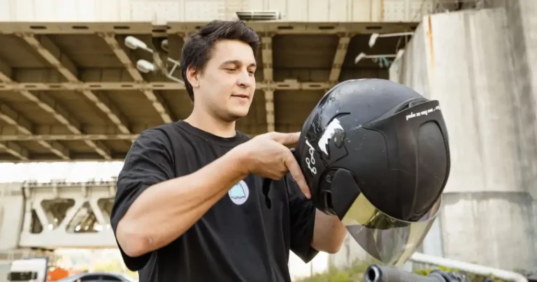 Come misurare la taglia del casco: motociclista con un casco jet in mano prima di indossarlo