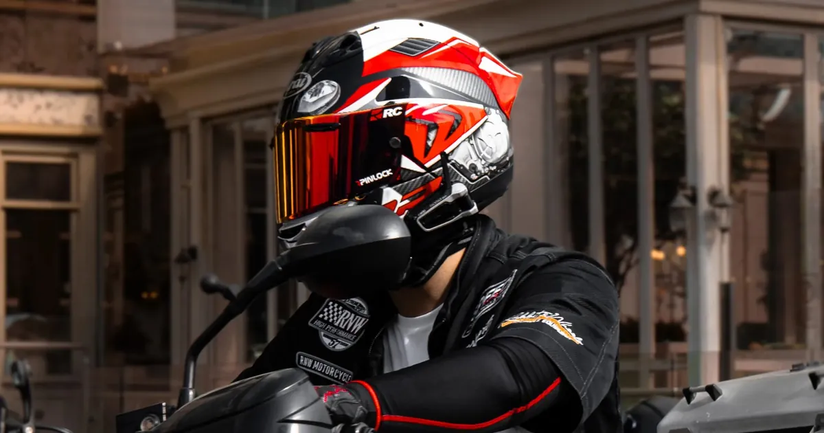 Sena 60S vs Cardo Packtalk Edge: motociclista con casco integrale in sella